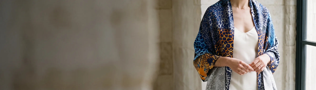 Woman wearing a blue leopard print silk shawl draped over her shoulders beside a tall window