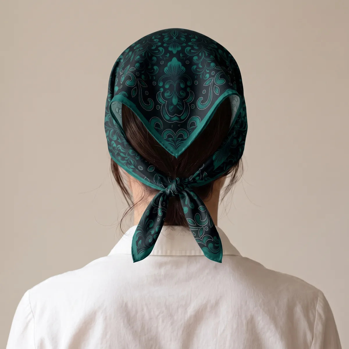 Back view of the black scrollwork bandana over the hair, the corners knotted at the nape