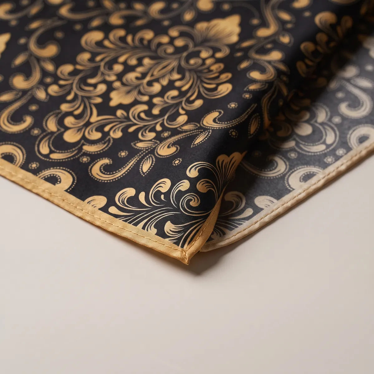 Corner of the black and gold baroque bandana: gold scrolls, tiny dots and the narrow gold hem