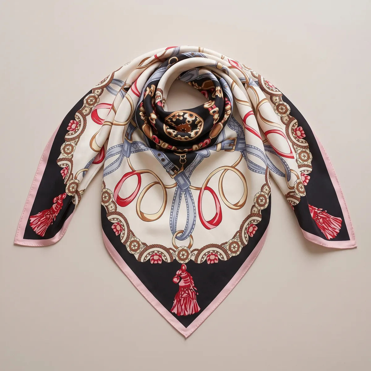 Silk shawl in black and cream twisted at the center and laid out in a triangle, a red tassel at the point