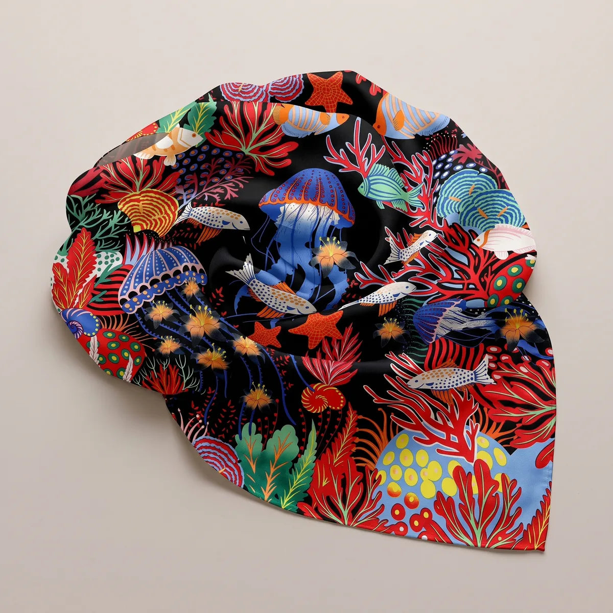 Black and red reef print shawl gathered in a loose round, a blue jellyfish and coral branches on top