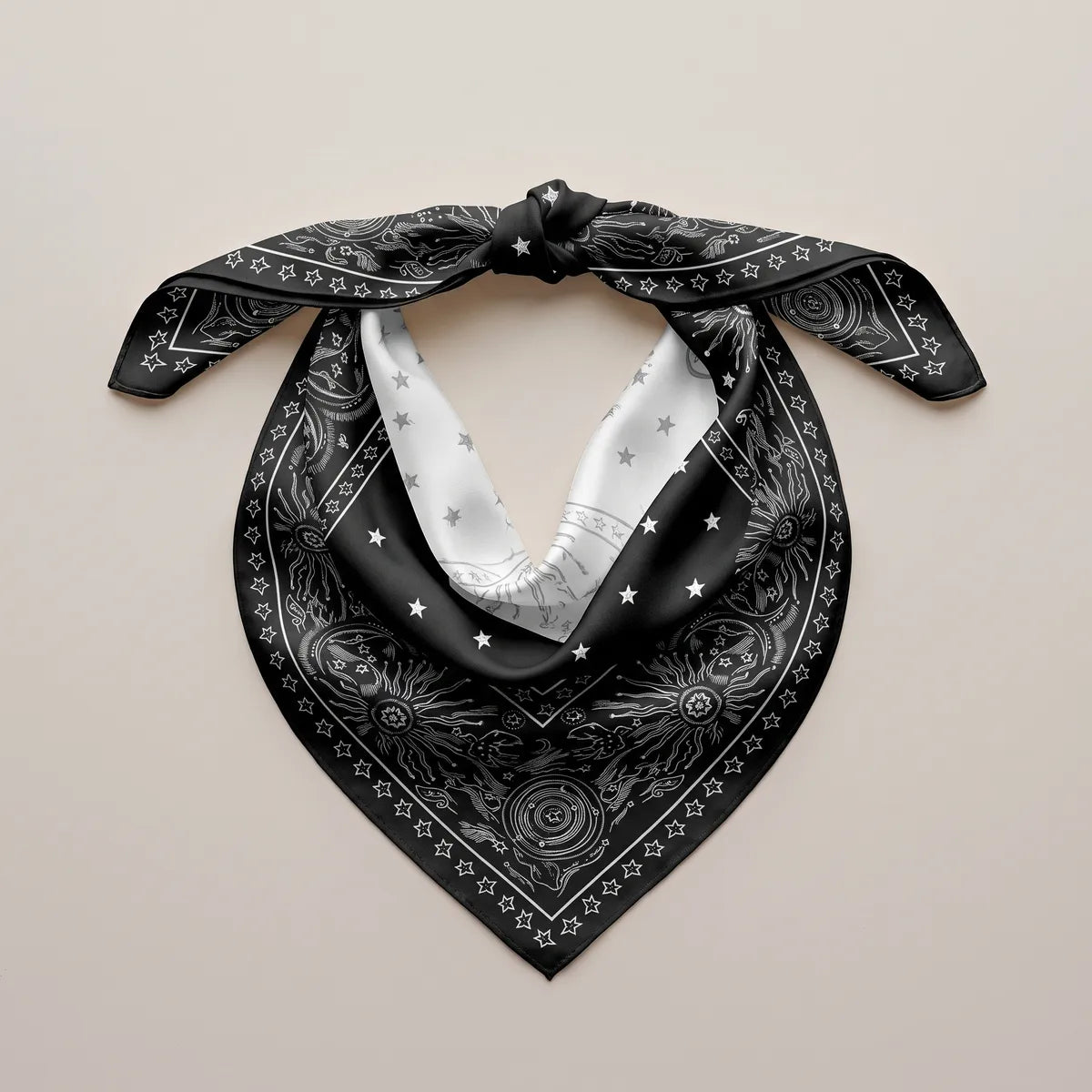 Black silk bandana knotted into a loop, pale reverse showing inside, star border on the front