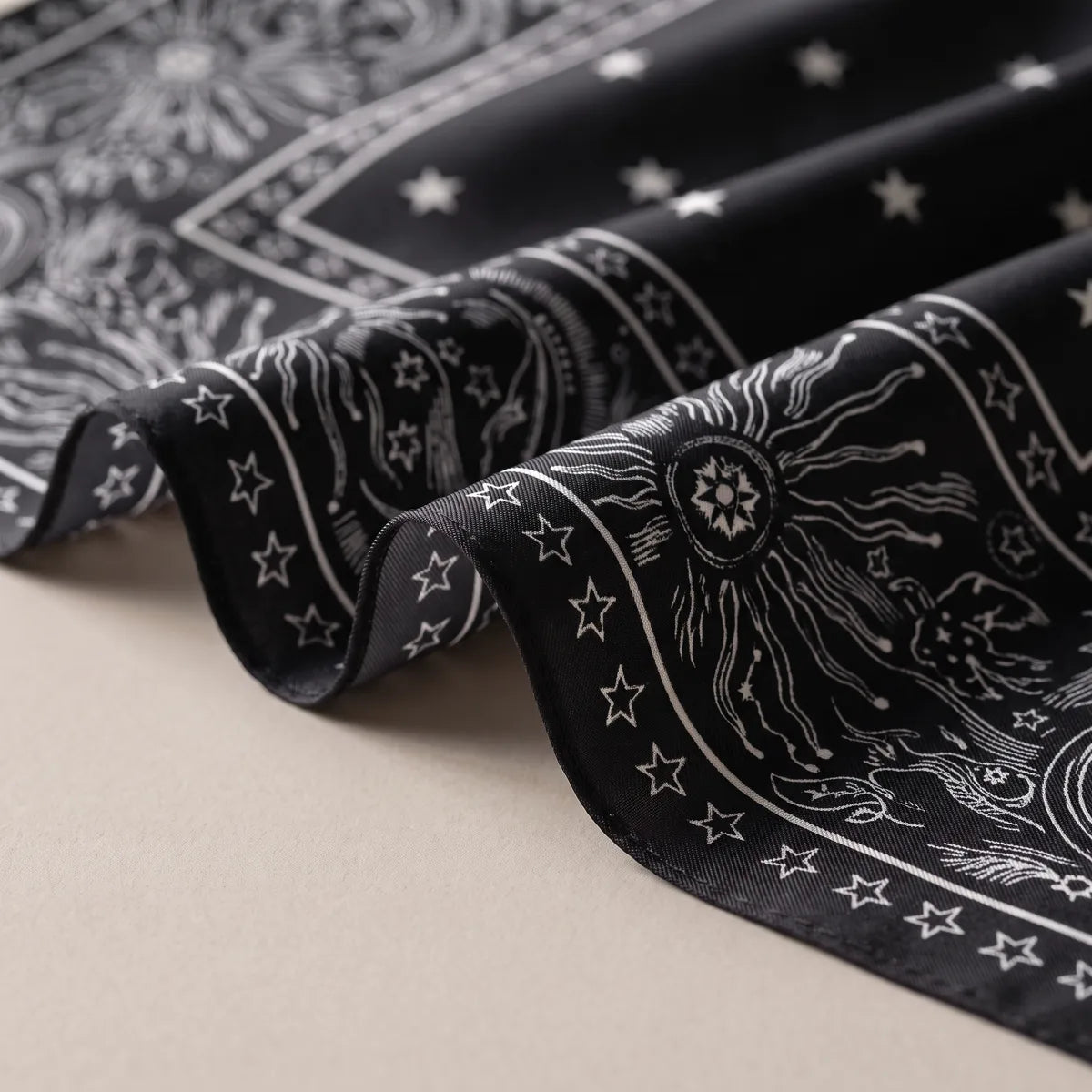 Close view of the black bandana border: white sunbursts, orbit rings and a row of small stars