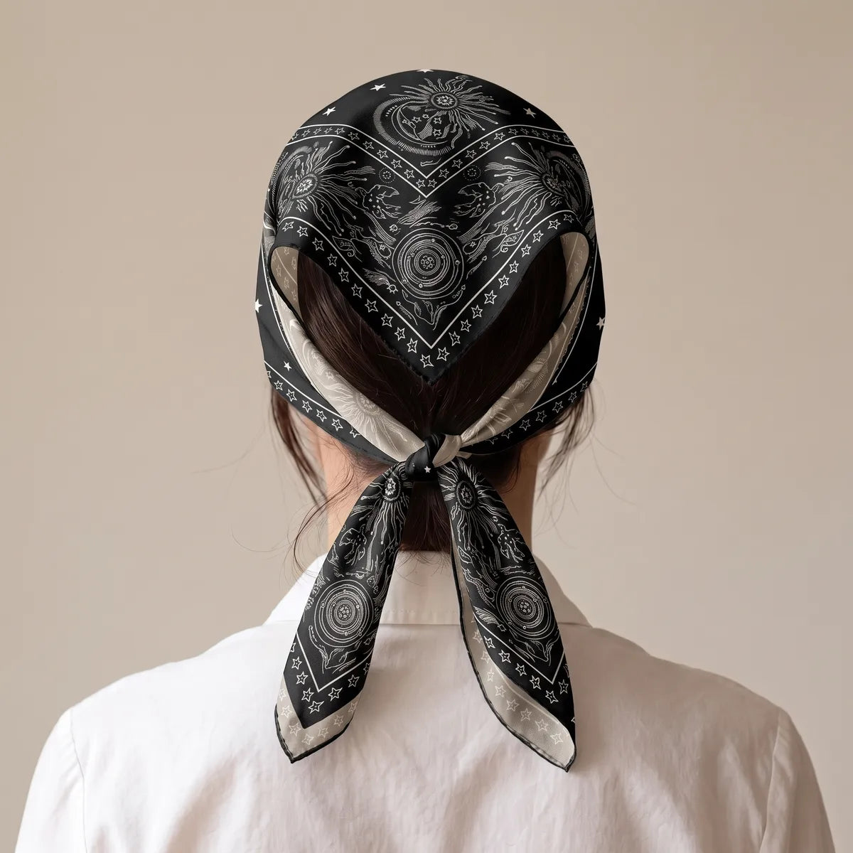 Black star print bandana worn as a head kerchief and tied at the nape, pale reverse at the edges
