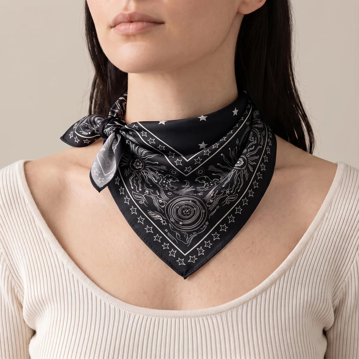 Woman wearing the black star print bandana at the neck, knot at one side