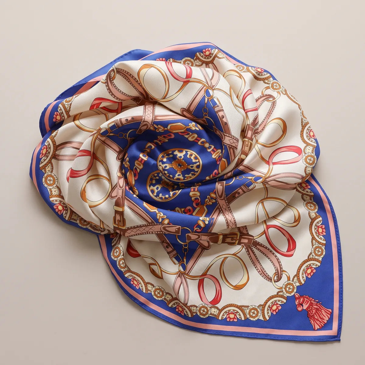 Blue chain print shawl twisted into a rose shape, the royal blue star spiraling at its center