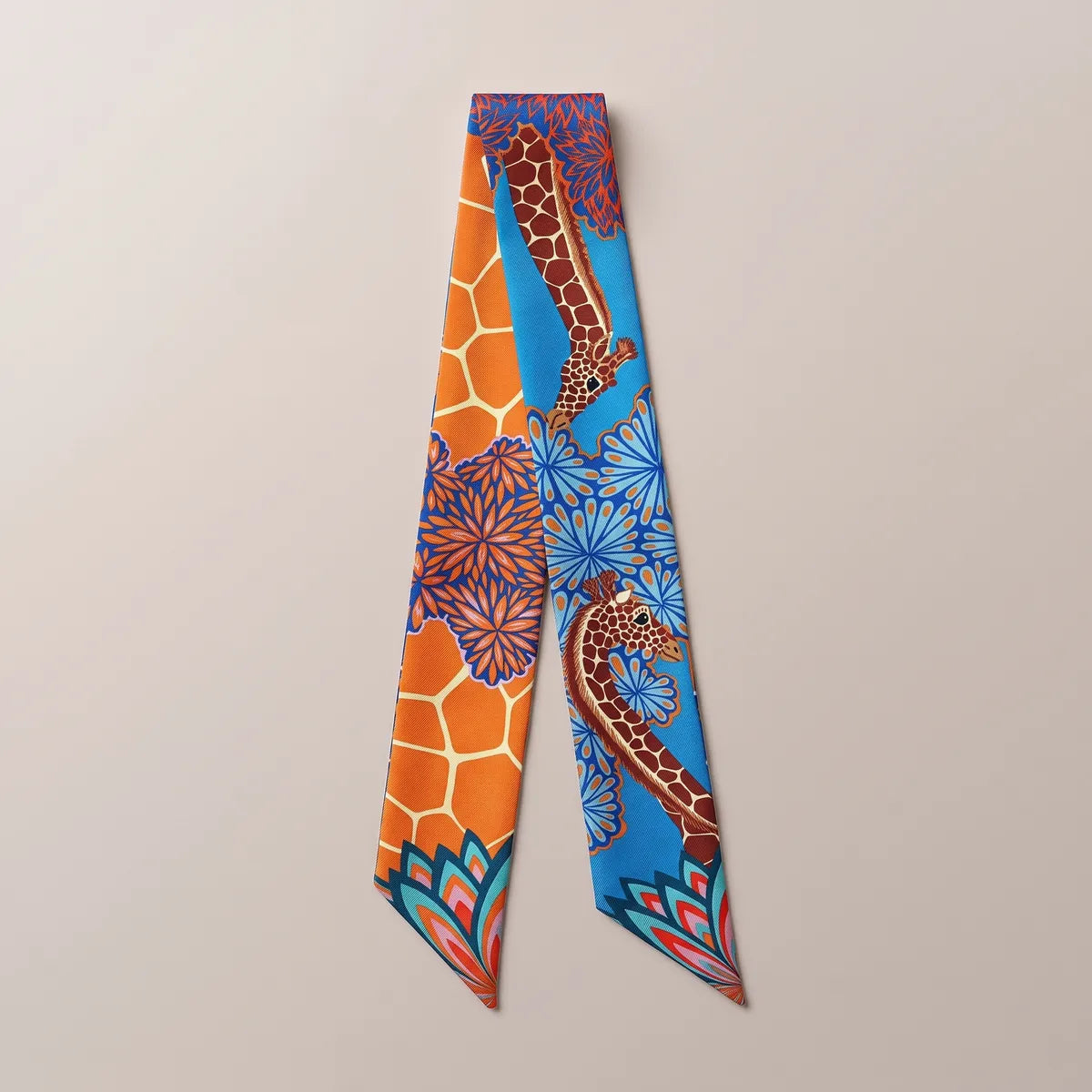 Blue giraffe print skinny silk scarf laid flat: brick red giraffes and blue flowers on azure, orange honeycomb panel