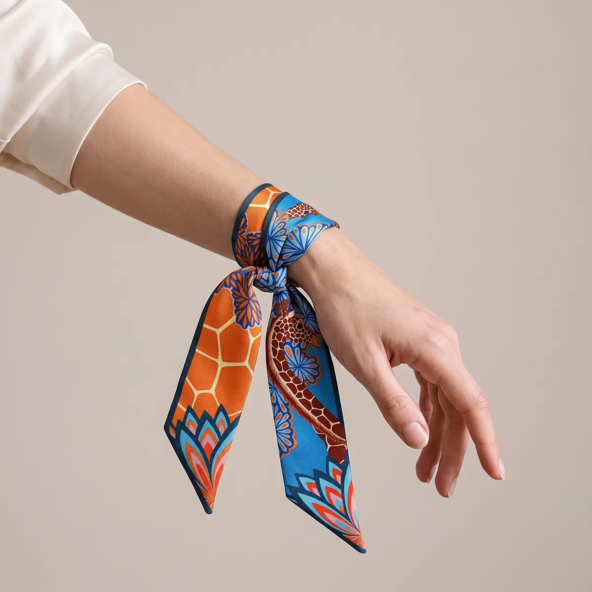 Blue and orange giraffe print skinny scarf tied around the wrist