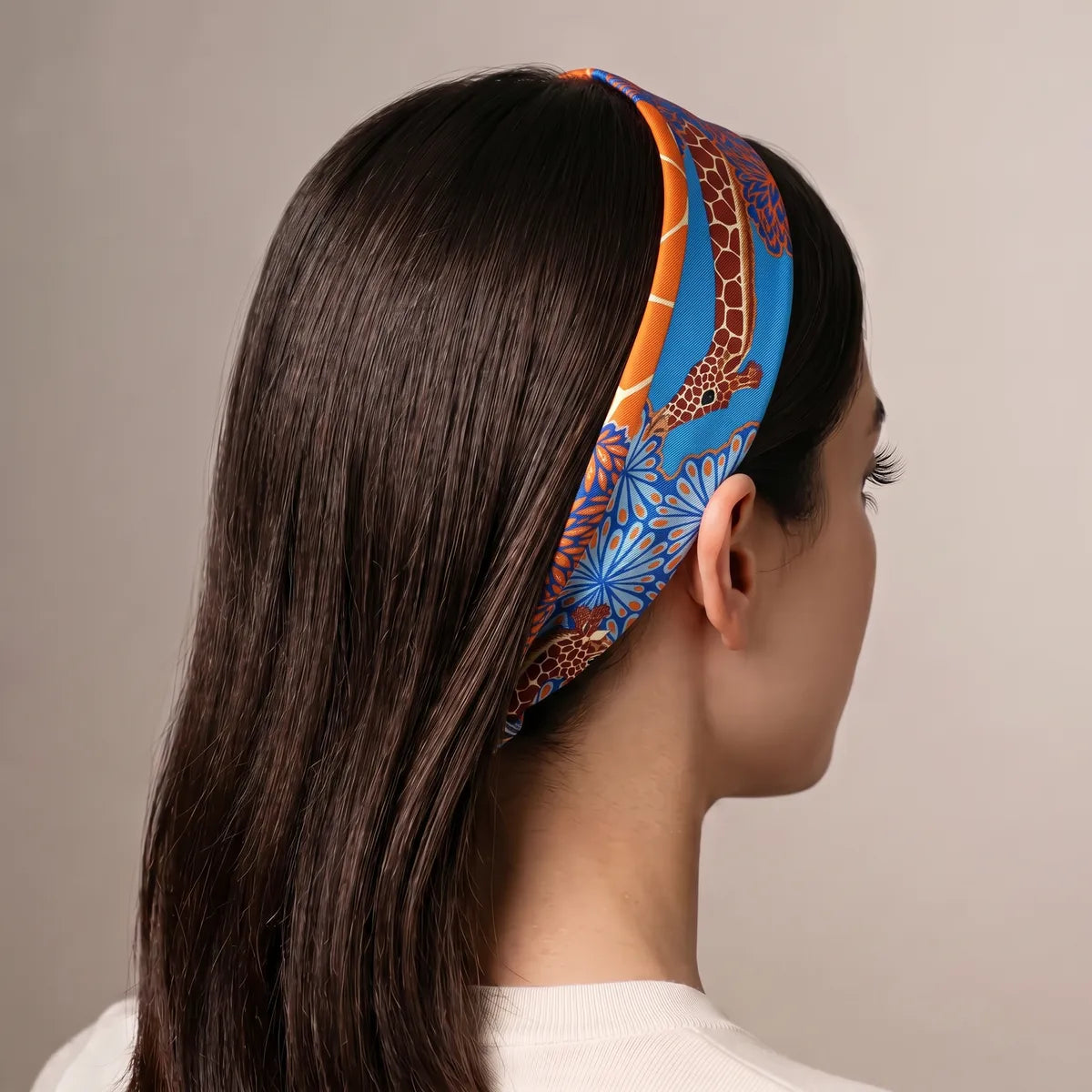 Azure giraffe skinny scarf used as a headband over long dark hair, seen from behind