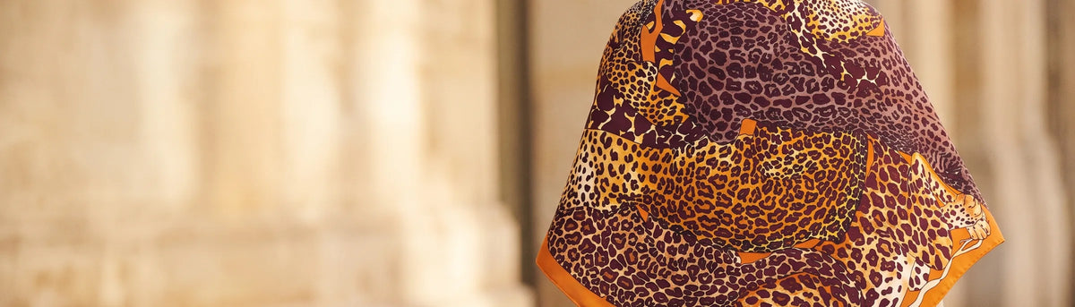 Back view of a woman wearing a tawny leopard print silk shawl over her shoulders