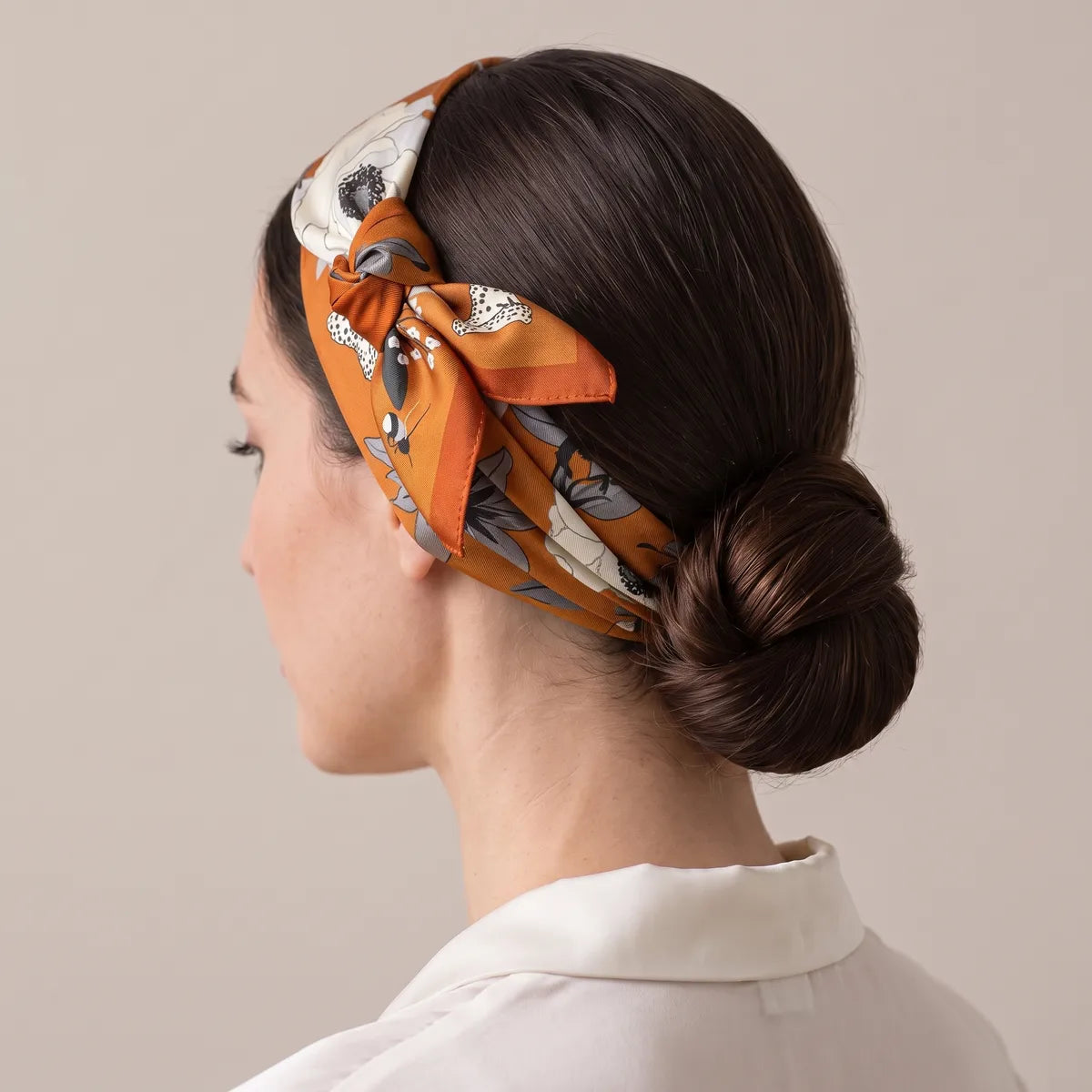 Burnt orange bandana as a headband over a low bun, knot above the ear