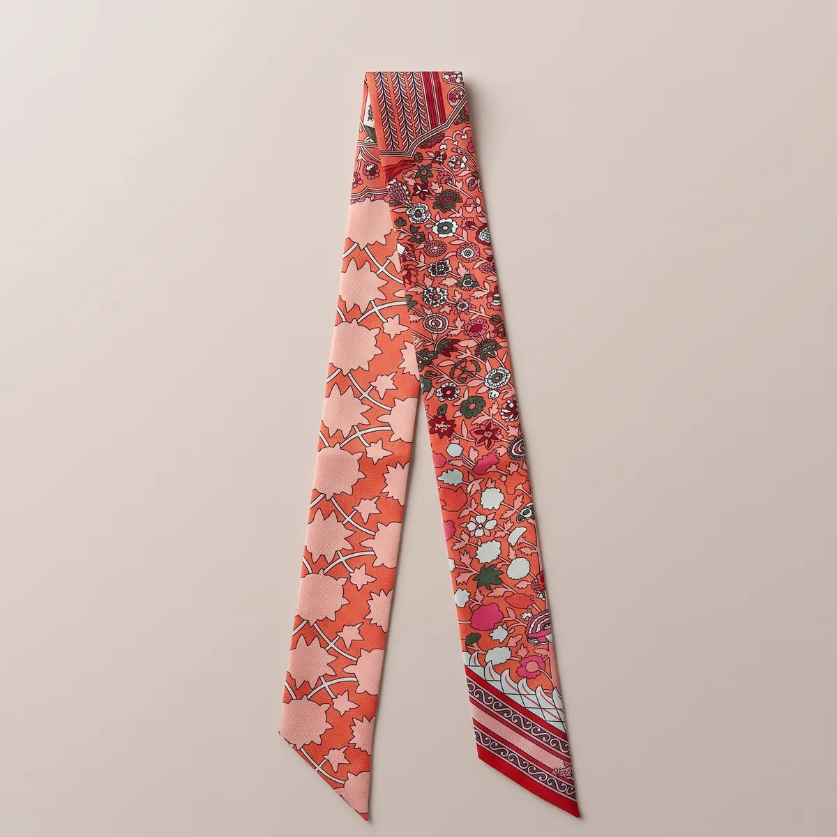 Coral floral skinny silk scarf laid flat in two strands: blush star-shaped leaves and small pink flowers on coral