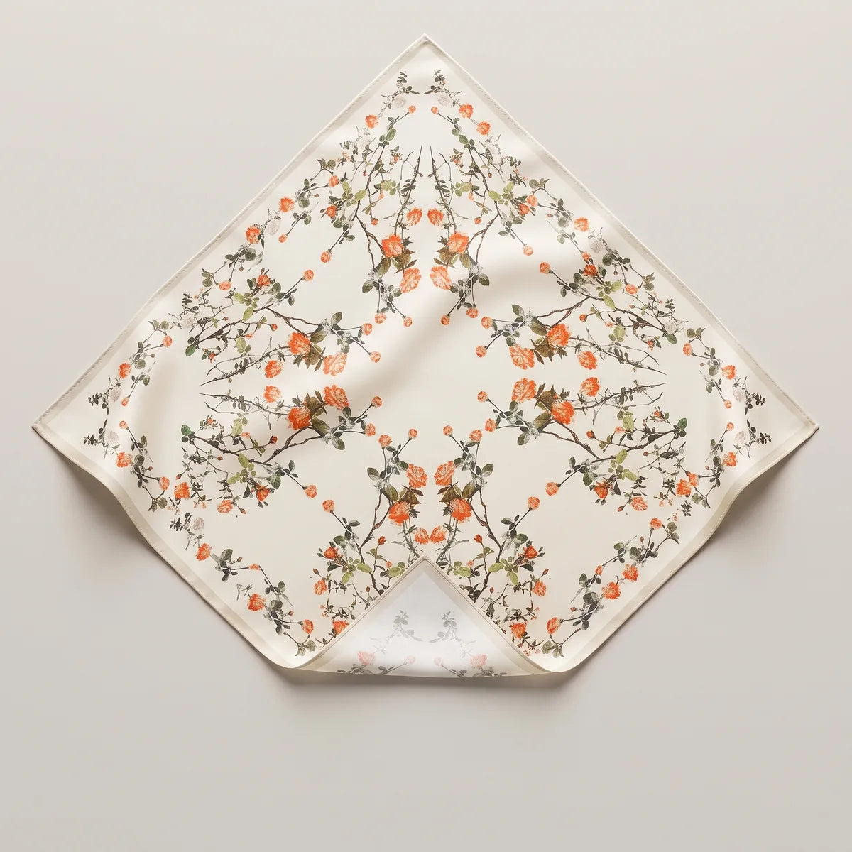 Cream blossom silk bandana on its point, mirrored sprays of coral flowers and sage leaves on cream