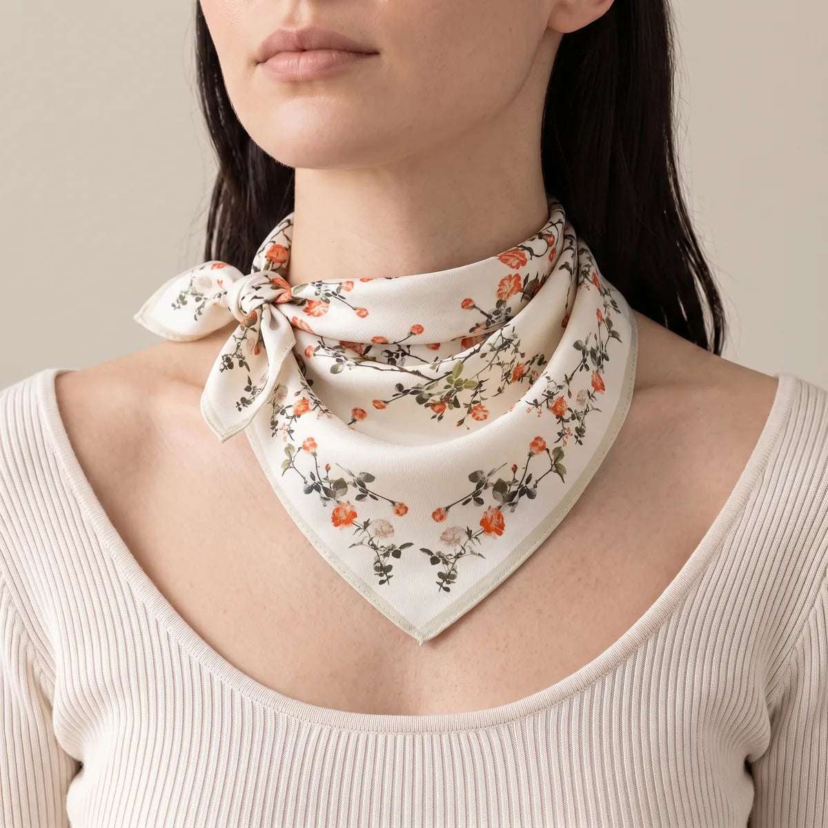 Cream floral silk bandana knotted at one side of the neck over an ivory ribbed top
