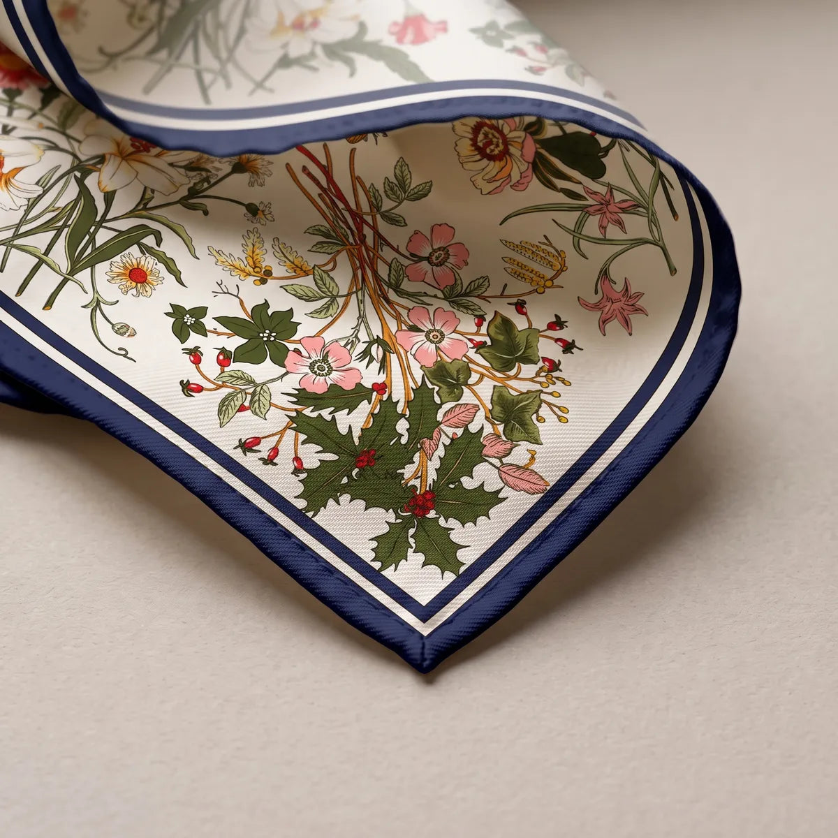 Corner of the cream shawl: a holly sprig, pink flowers and the navy and white border