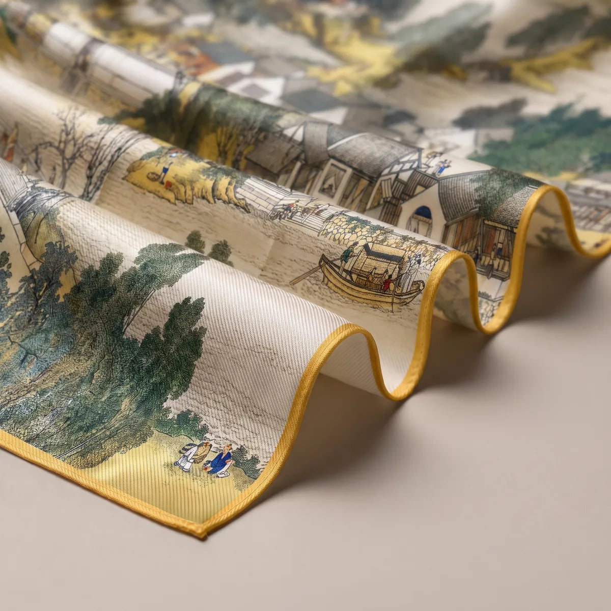 Waves of the landscape scarf showing houses, a small boat on the river and the mustard yellow edge