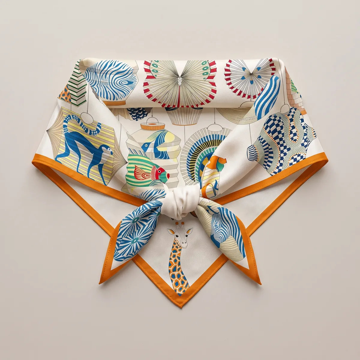 Lantern print silk square knotted and laid flat, a giraffe lantern at the point and orange edges