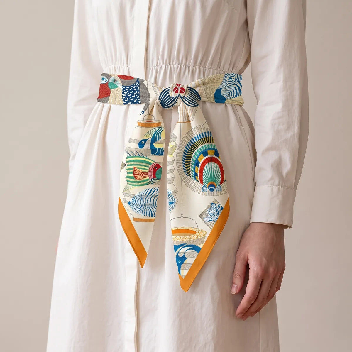 Silk lantern square as a belt on a white shirtdress, the knot centered