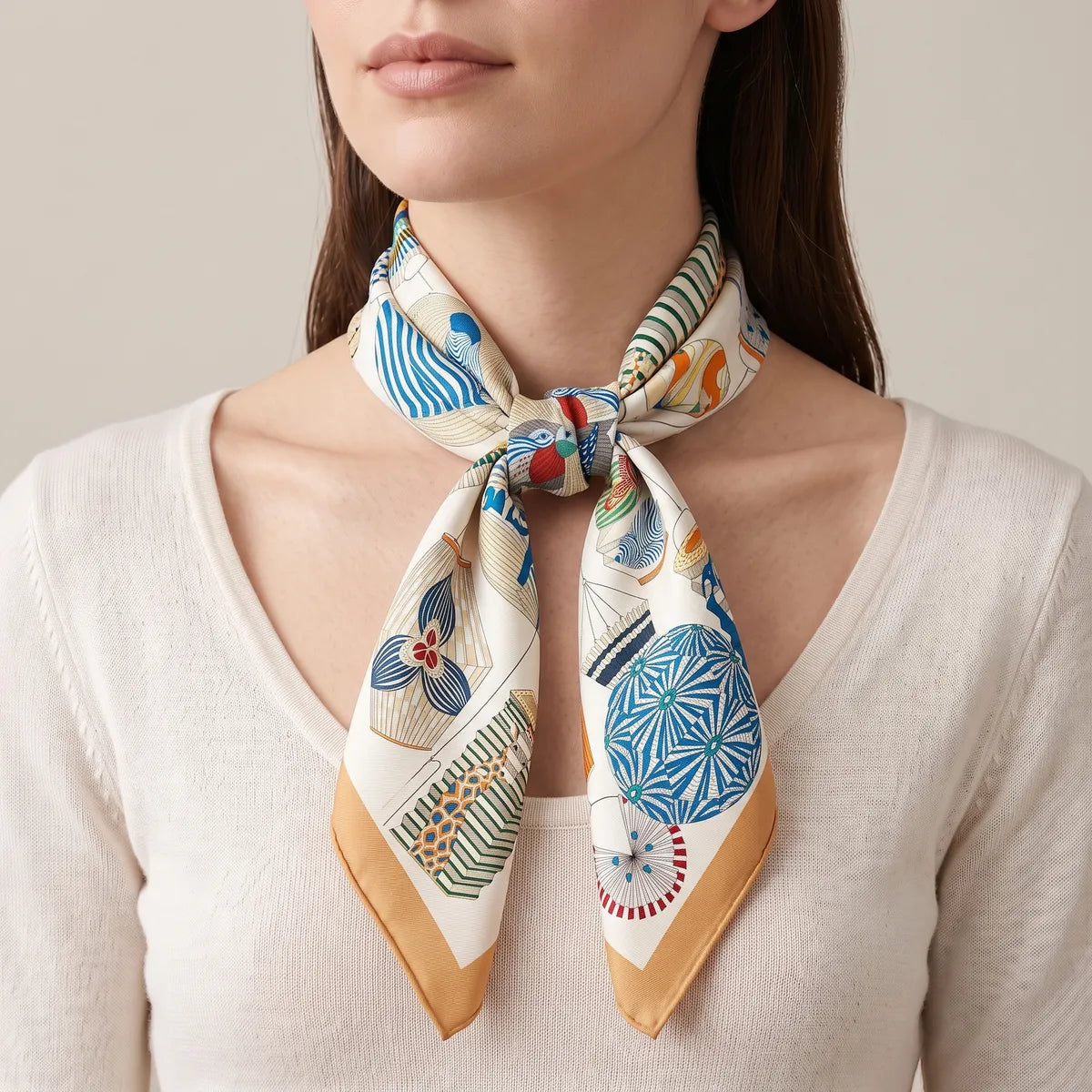 Lantern print silk square tied at the neck, orange-edged tips over a cream sweater