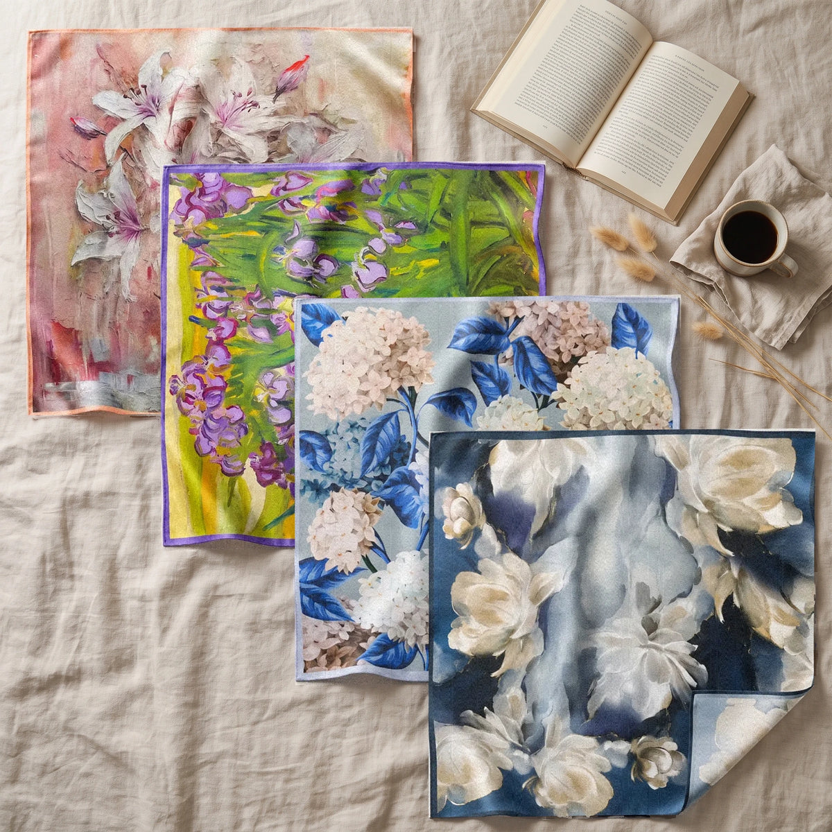 Pink lily, green iris, blue hydrangea and navy floral bandanas spread on linen beside a book