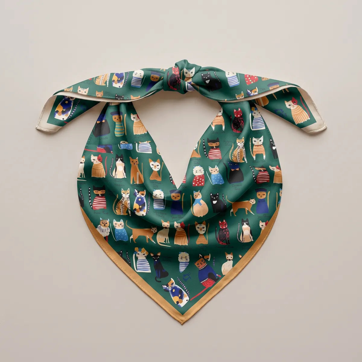 Cat print bandana with a knot at the top, laid out flat so the green silk hangs in a soft V