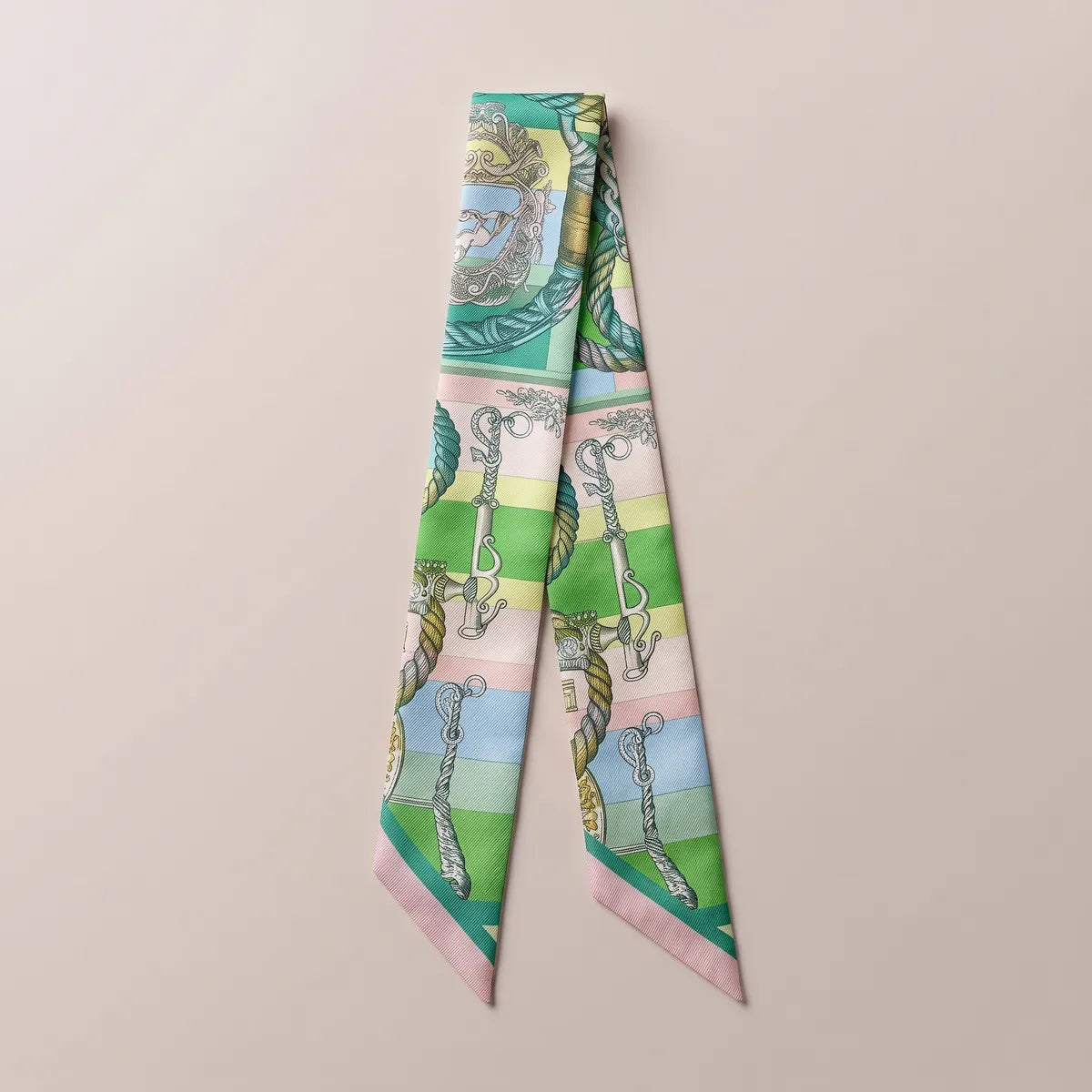 Green chain print skinny silk scarf laid flat with gray chains and teal ropes over pastel color bands