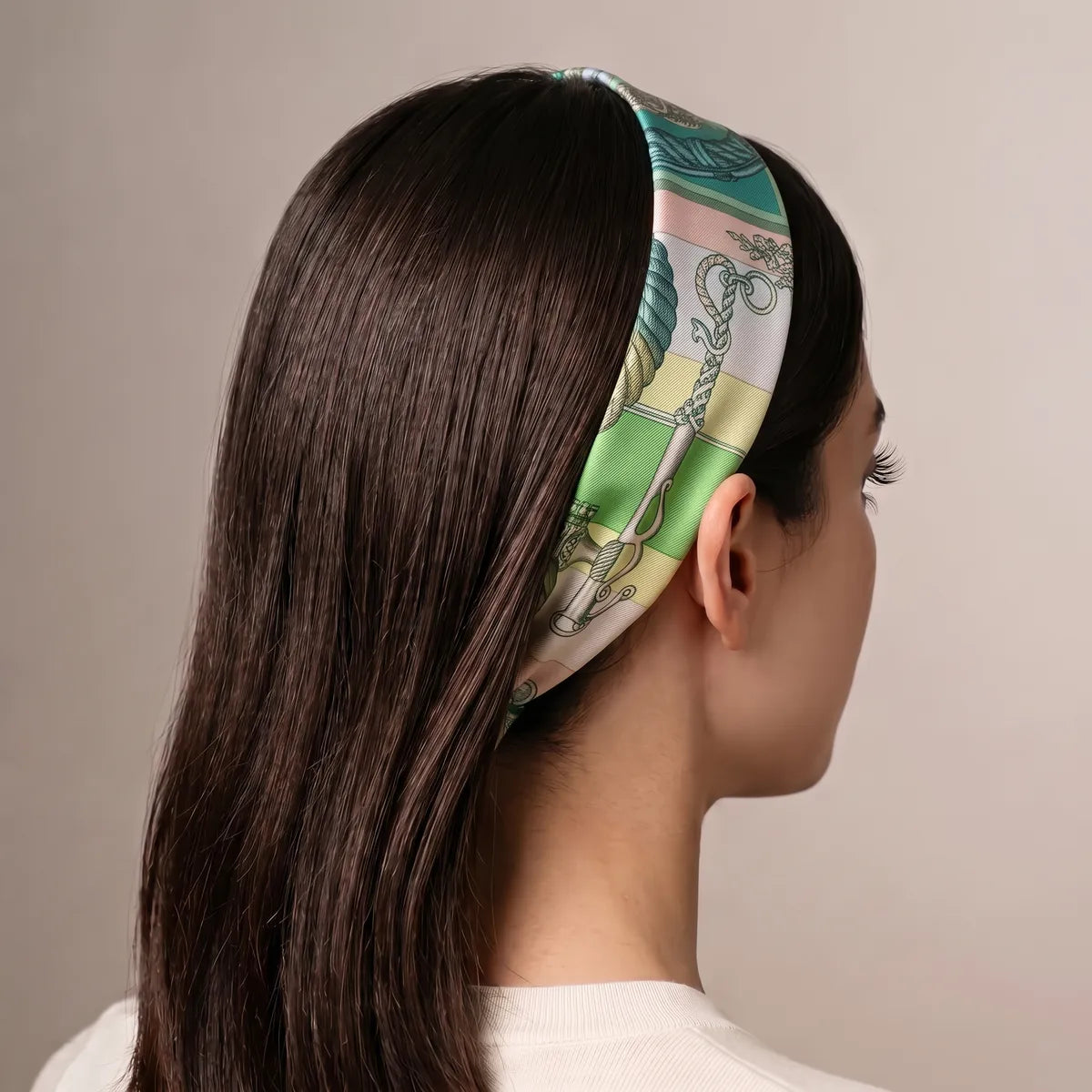 Green chain print skinny scarf worn as a headband on long straight hair