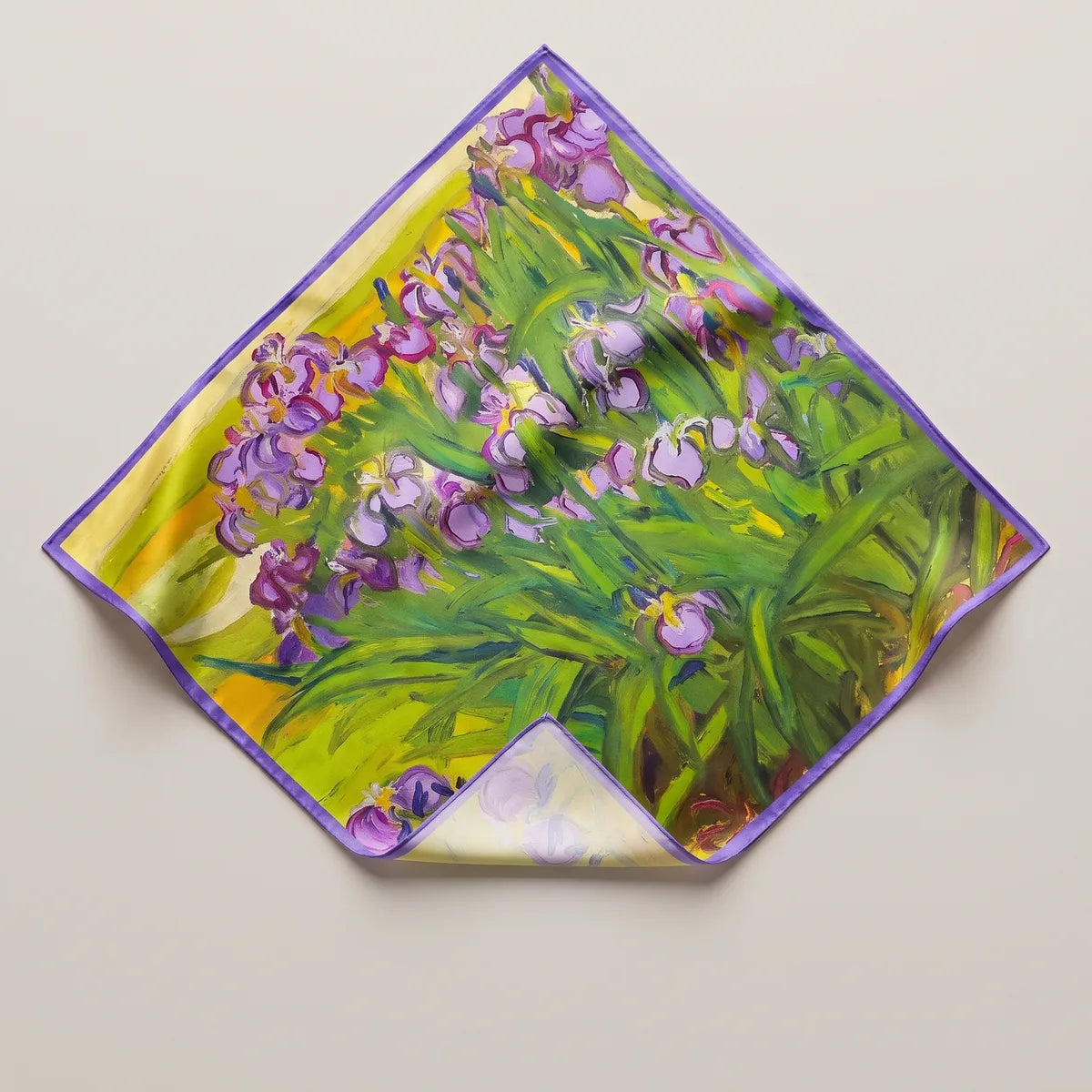 Green iris floral silk bandana laid on its point: purple irises in thick paint strokes, violet edge, corner folded back