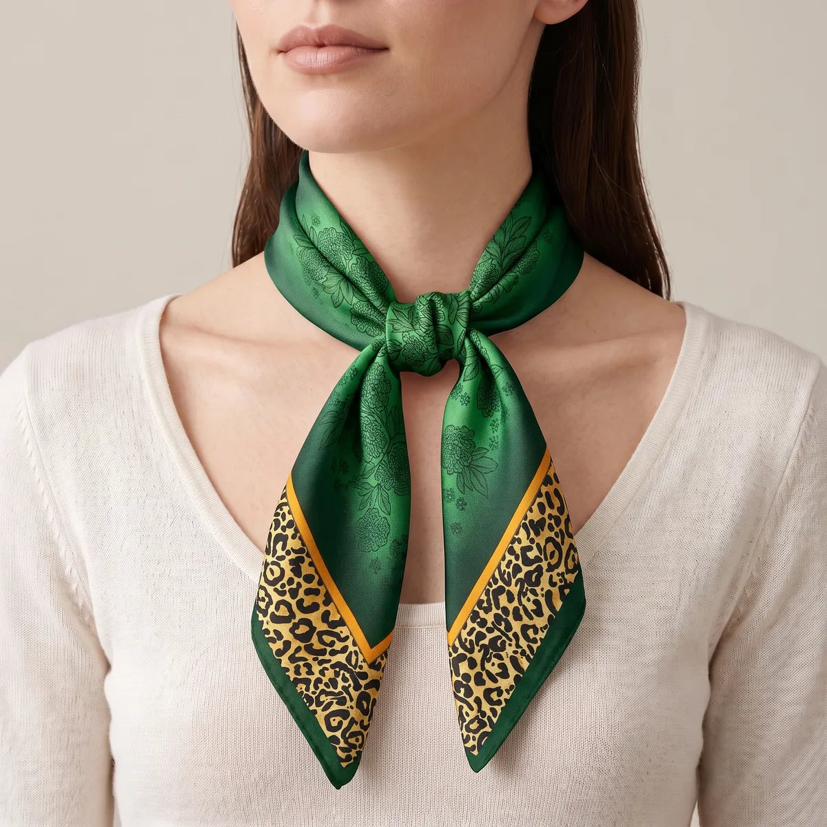 Deep green square knotted low at the neck, the leopard-spot border running down both tails