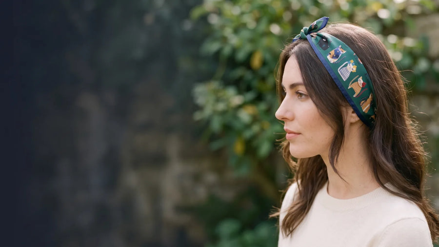 Woman in profile wearing a green cat print silk bandana as a headband
