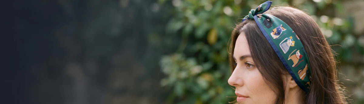 Woman in profile wearing a green cat print silk bandana as a headband