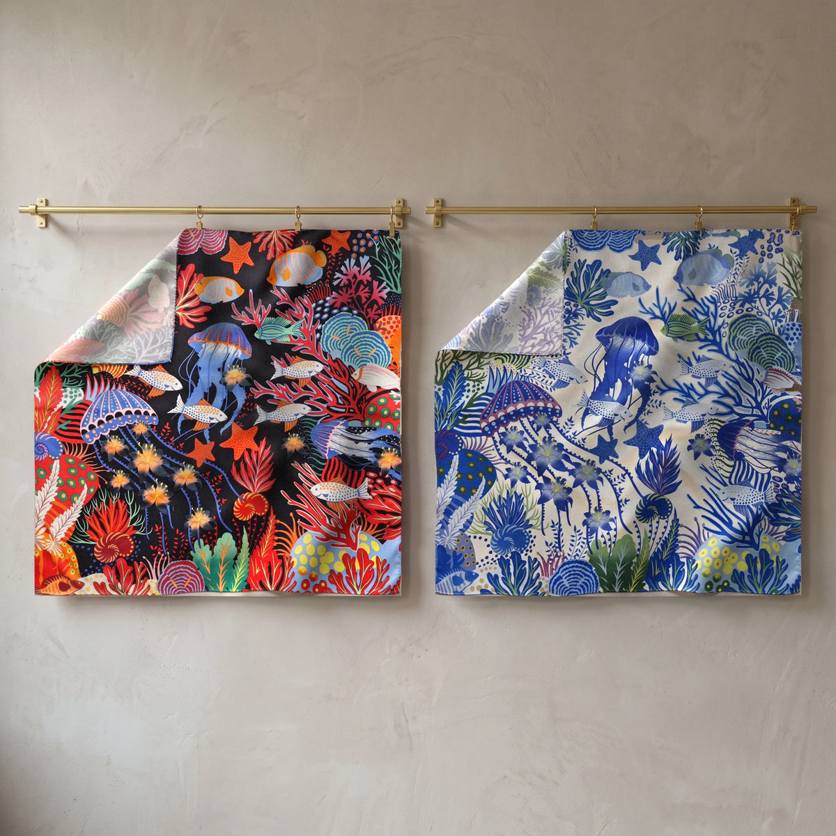 Black and blue jellyfish print silk shawls hanging side by side from brass rods