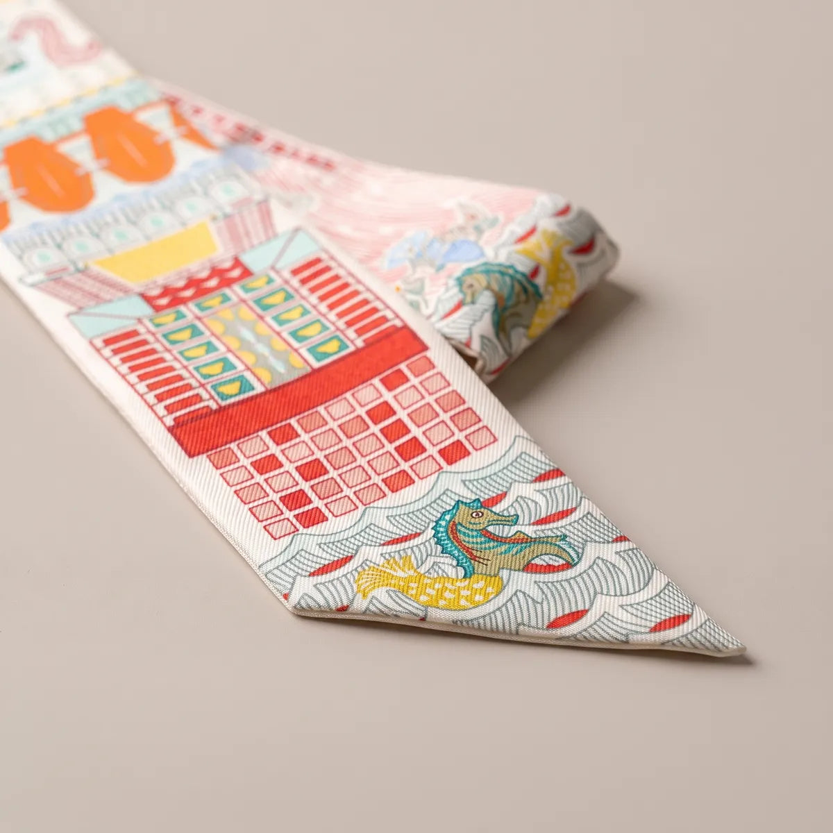 Close-up showing the pink colorway of the same building print: red brick facade and a seahorse on waves