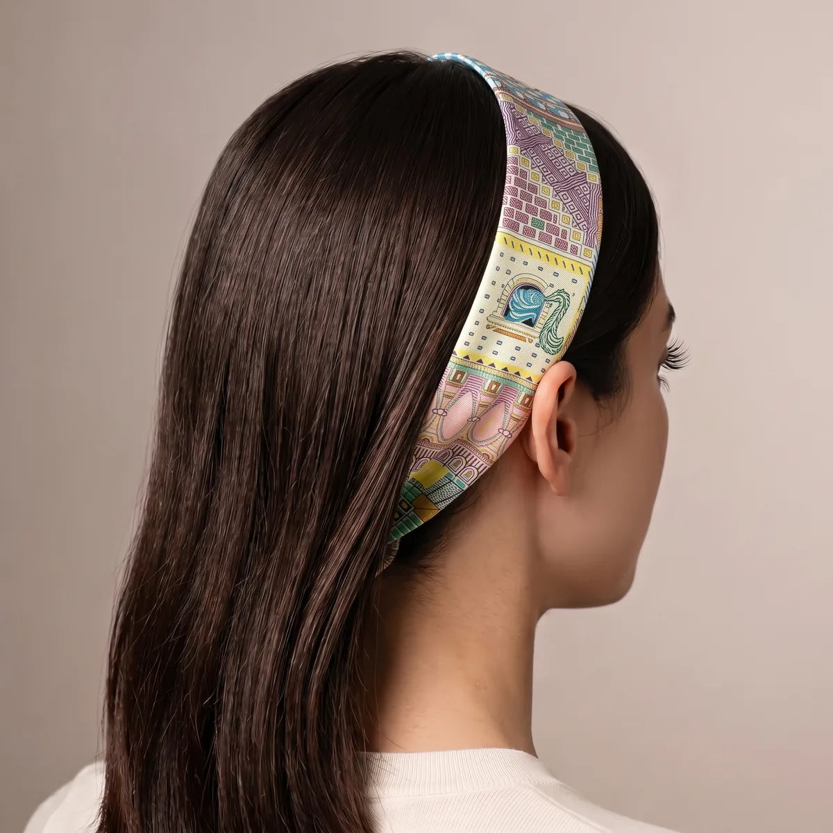 Light blue skinny scarf worn as a headband over long dark hair, seen from behind, lilac facades on top