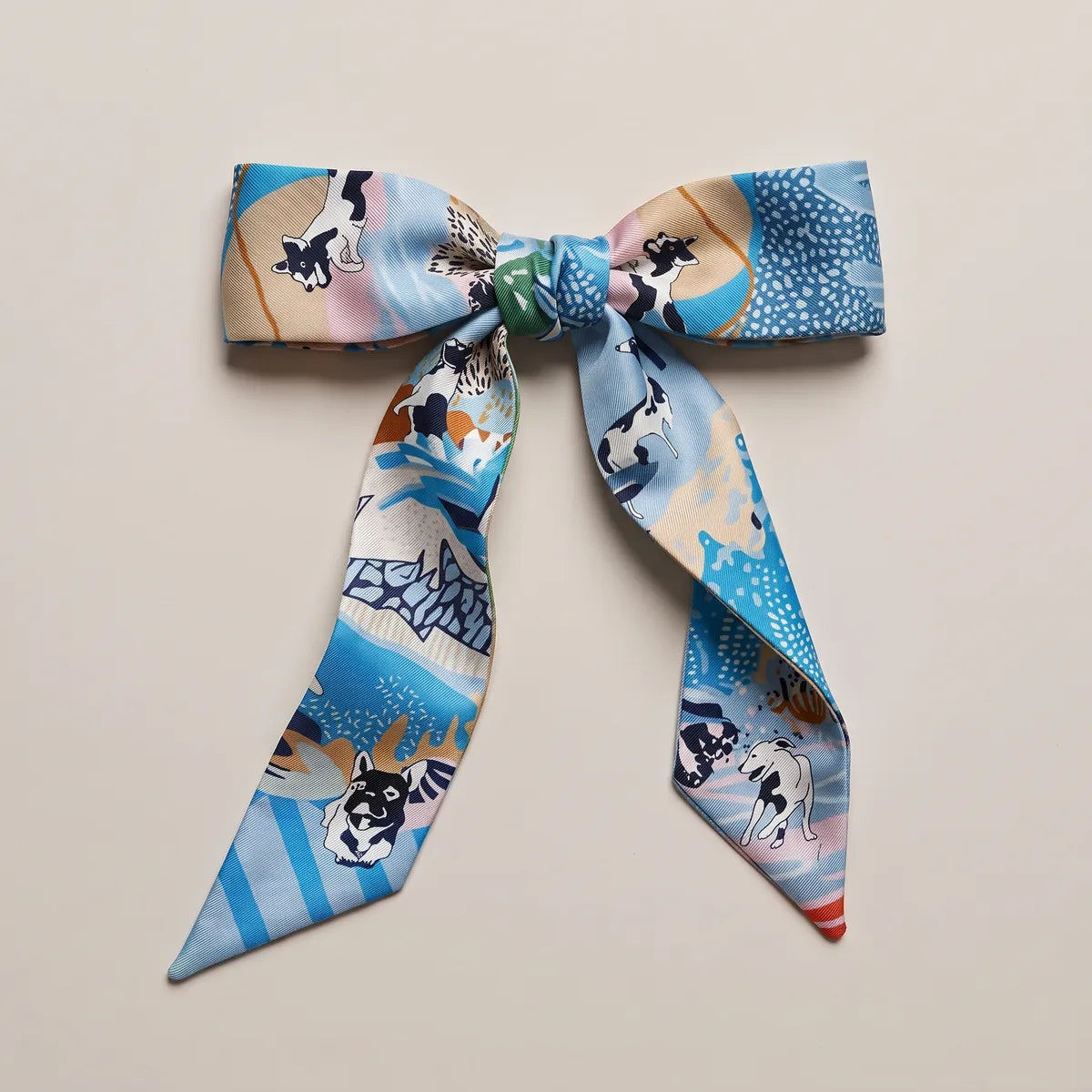 Light blue skinny silk scarf tied in a bow, a terrier on the left loop and dotted blue patches