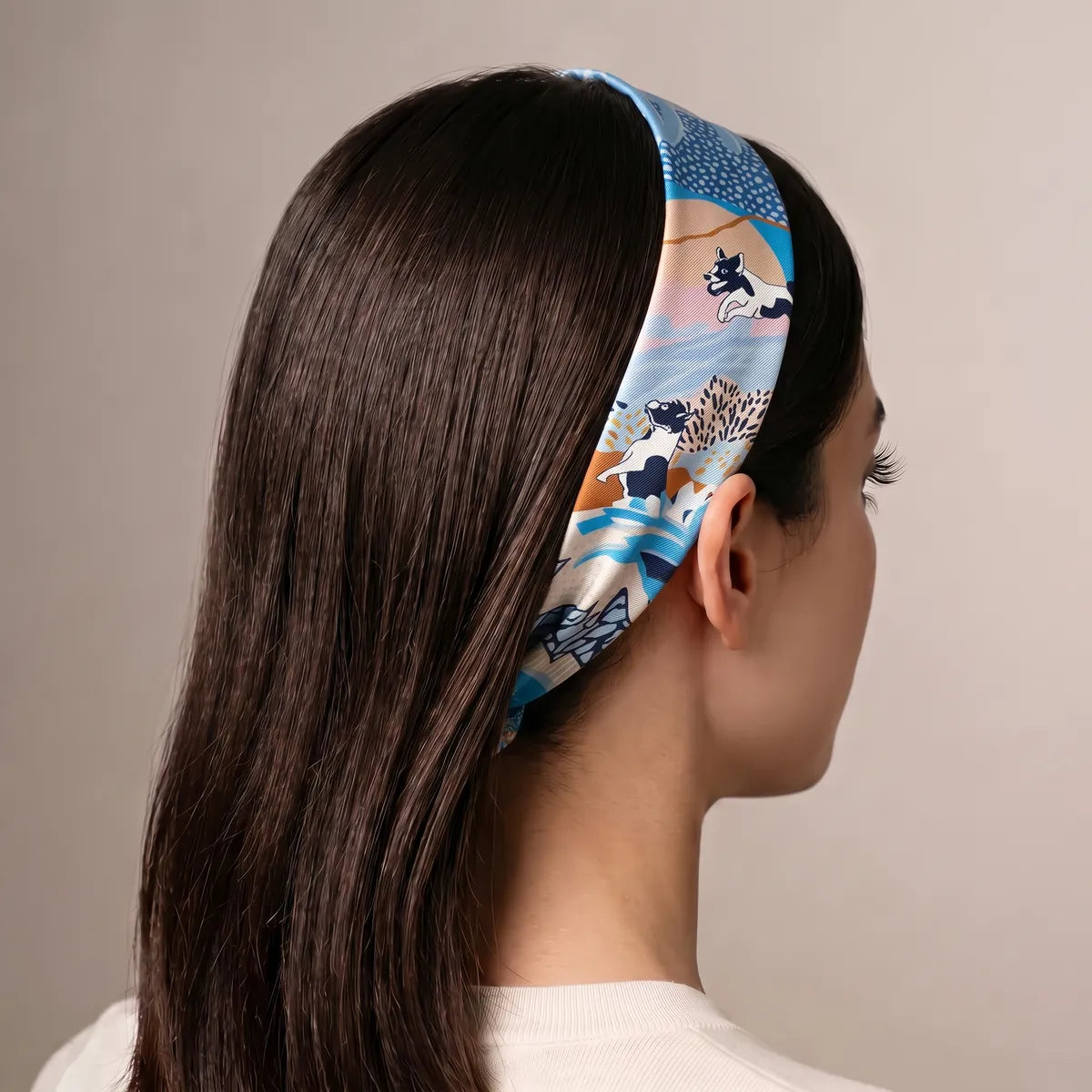 Light blue dog print skinny scarf worn as a headband, terriers along the band above the ear