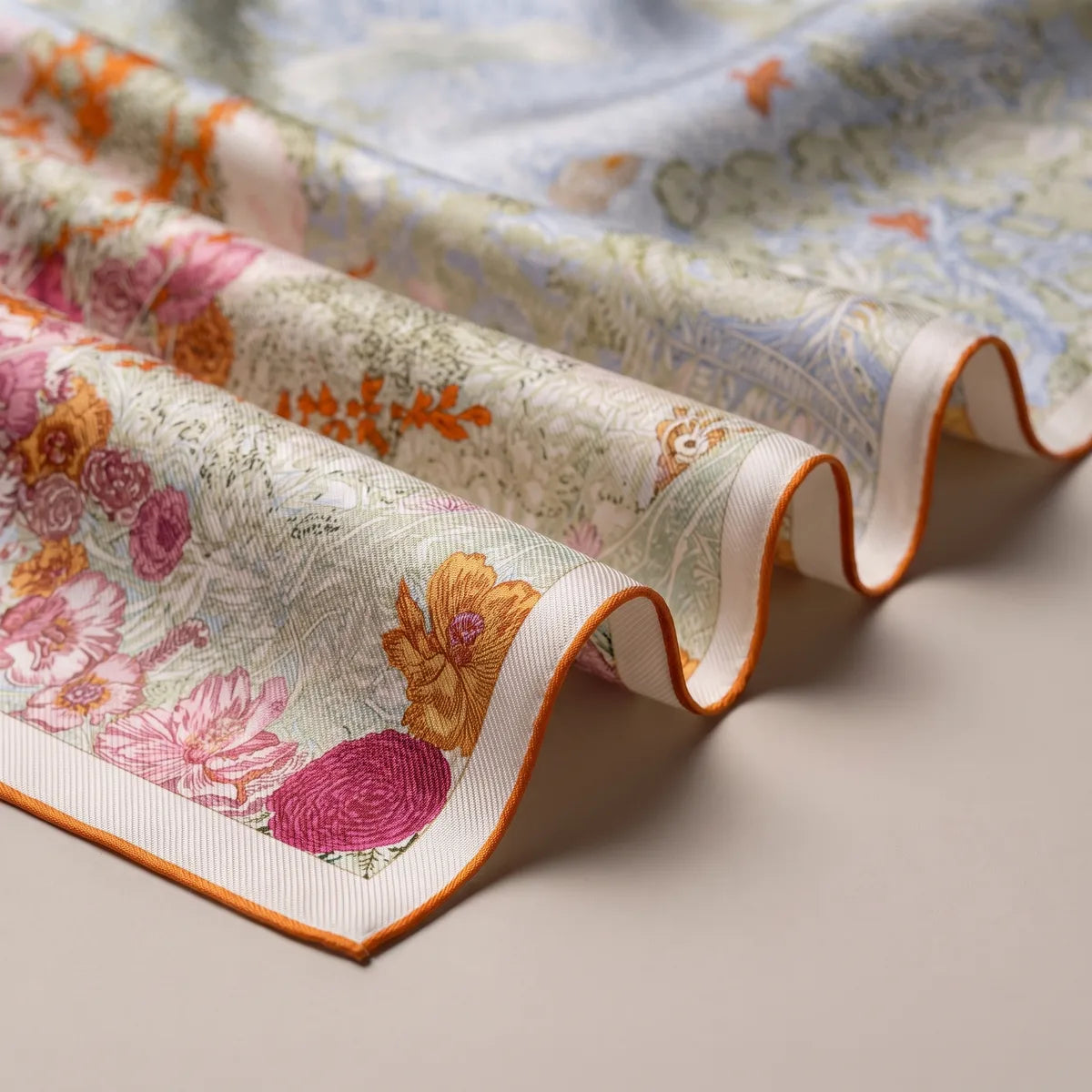Waves of the pastel scarf showing pink peonies, orange blooms and the pale pink border band
