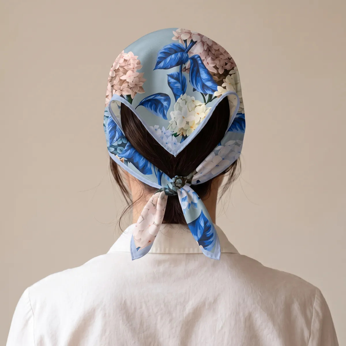 Rear view of the light blue hydrangea bandana over the hair, knotted at the nape