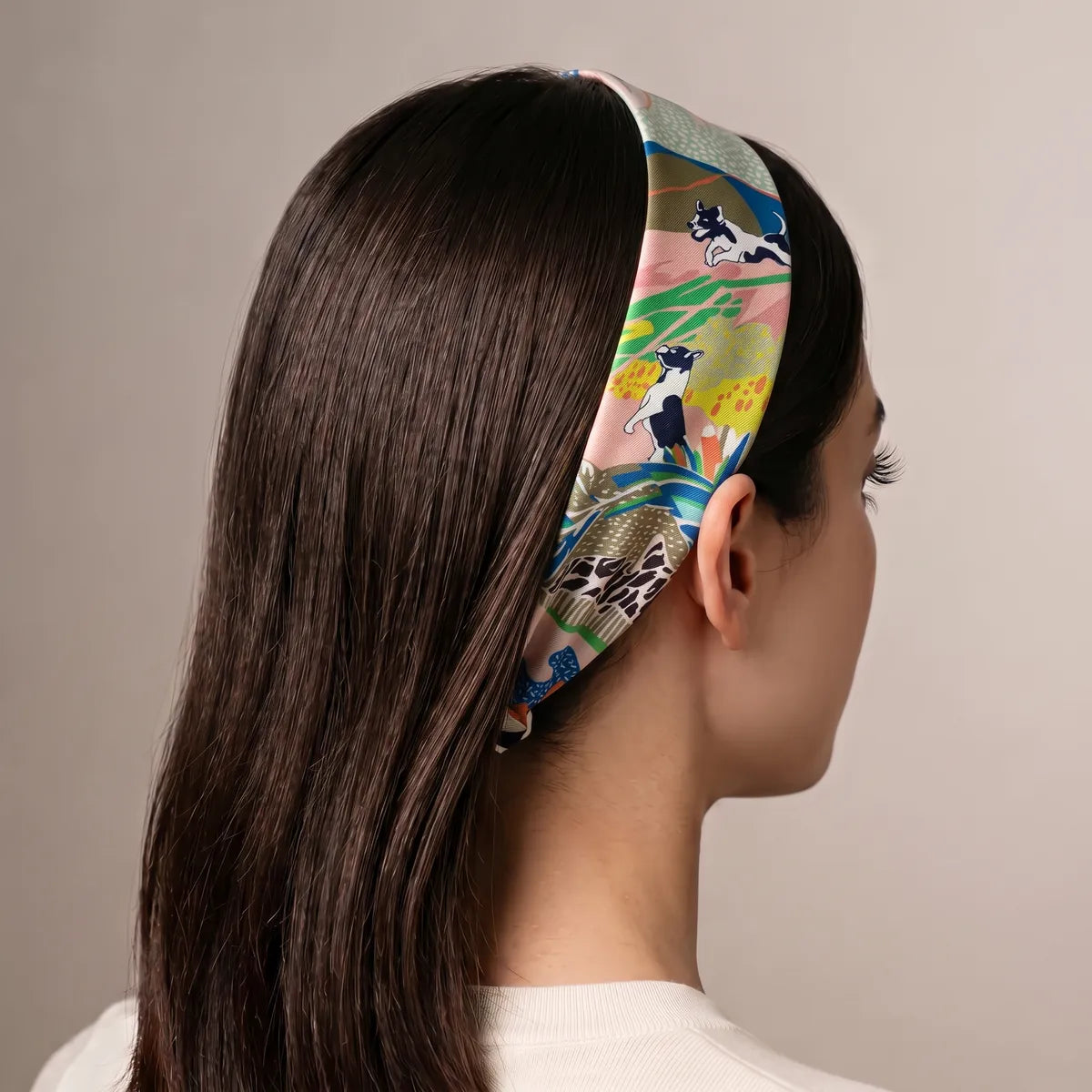 Multicolor dog print skinny scarf worn as a headband over long straight hair