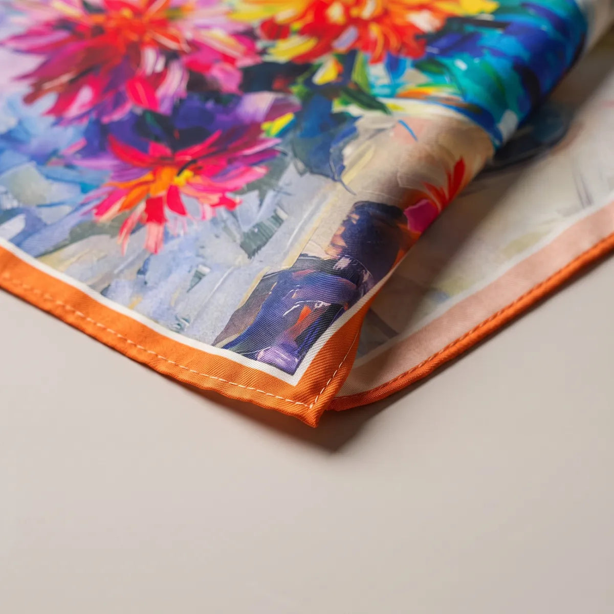 Magenta and orange blooms near an orange-edged corner of the bouquet bandana, its paler reverse folded over