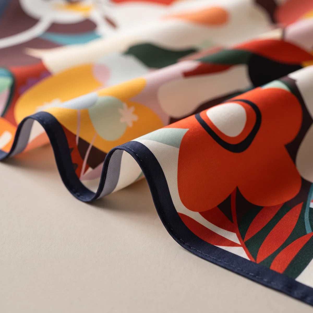 Navy-edged folds of the retro bandana, a large red-orange flower with a black-ringed center at the front