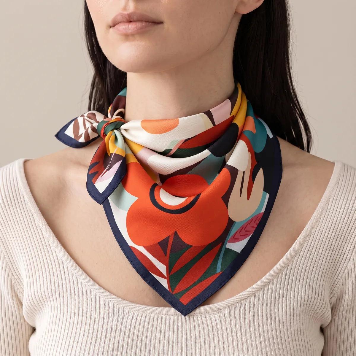 Retro floral silk bandana tied with a side knot at the neck, the red-orange flower at the front