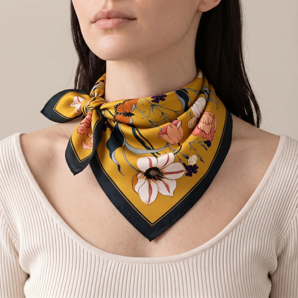 Woman wearing the mustard floral bandana as a neck scarf, knot at the side of her neck