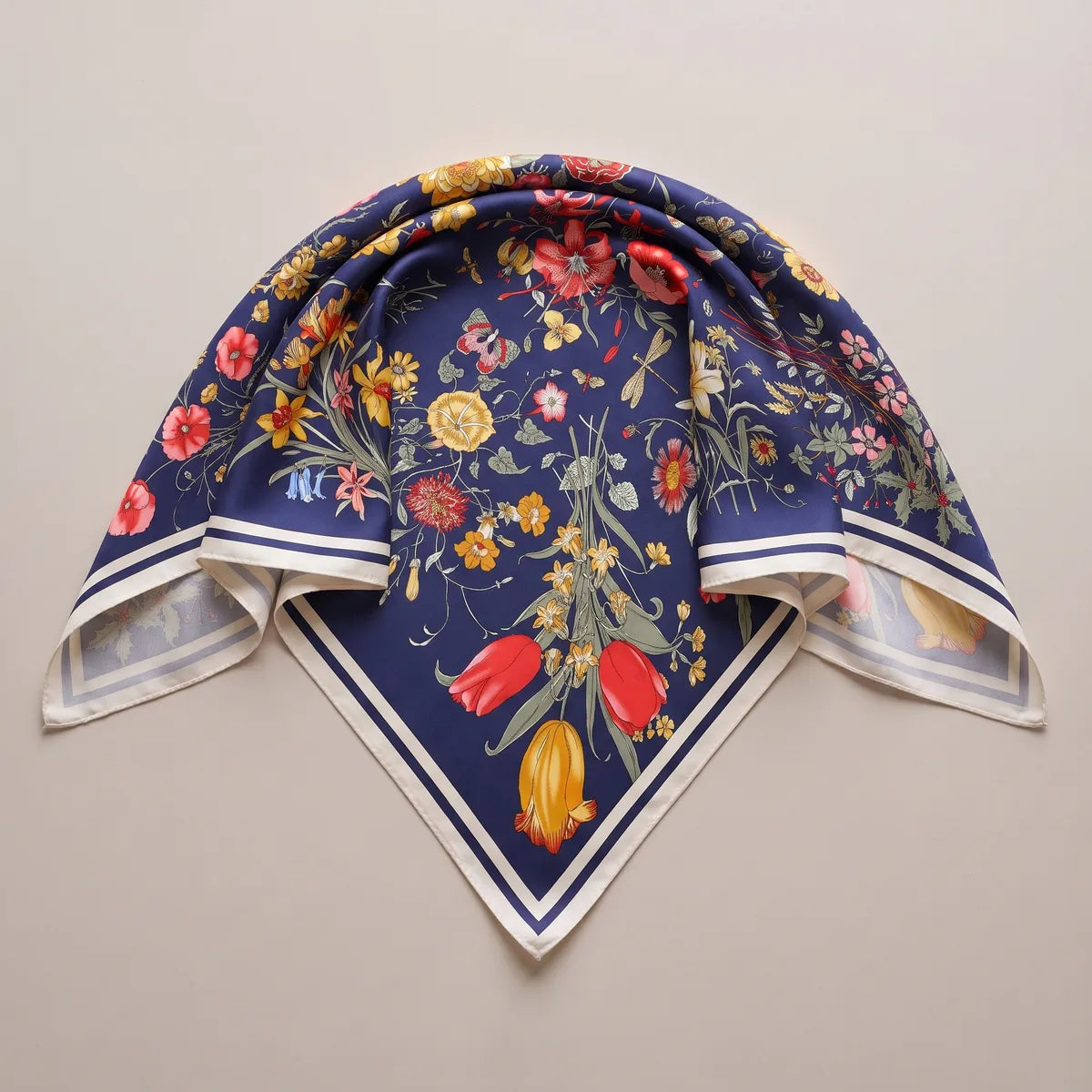 Navy floral silk shawl laid as a triangle, the cream border forming a V under a tulip bouquet