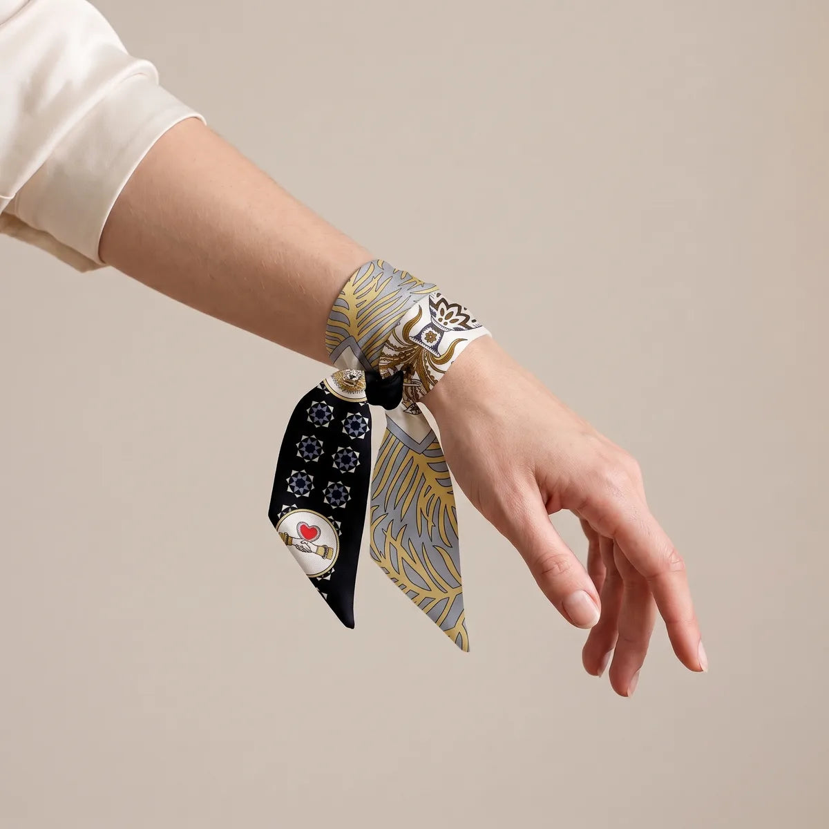 Navy skinny scarf knotted around the wrist, red heart medallion on the hanging end