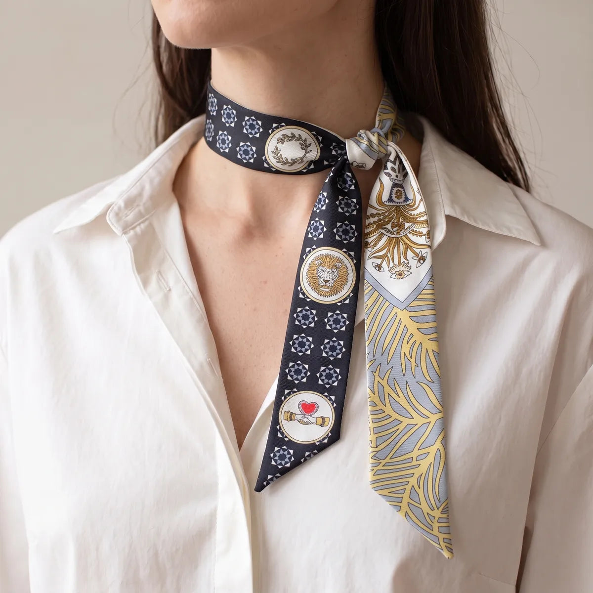 Navy medallion print skinny scarf tied off to the side at the neck over a white shirt
