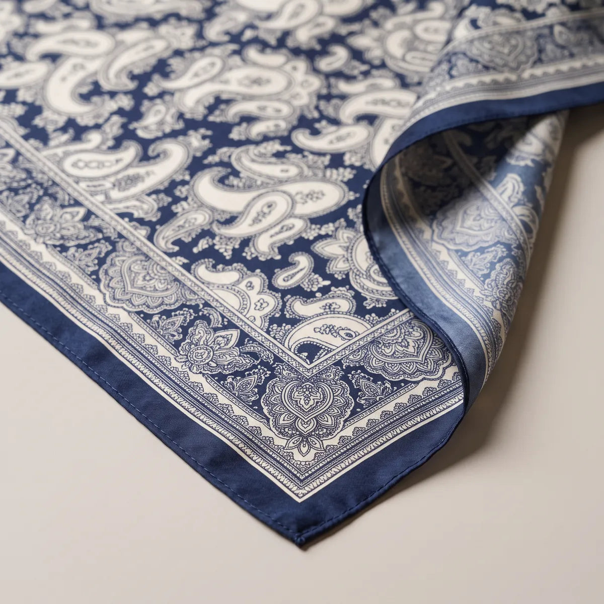 Scalloped paisley border and navy edge of the bandana, with the lighter blue reverse folded over