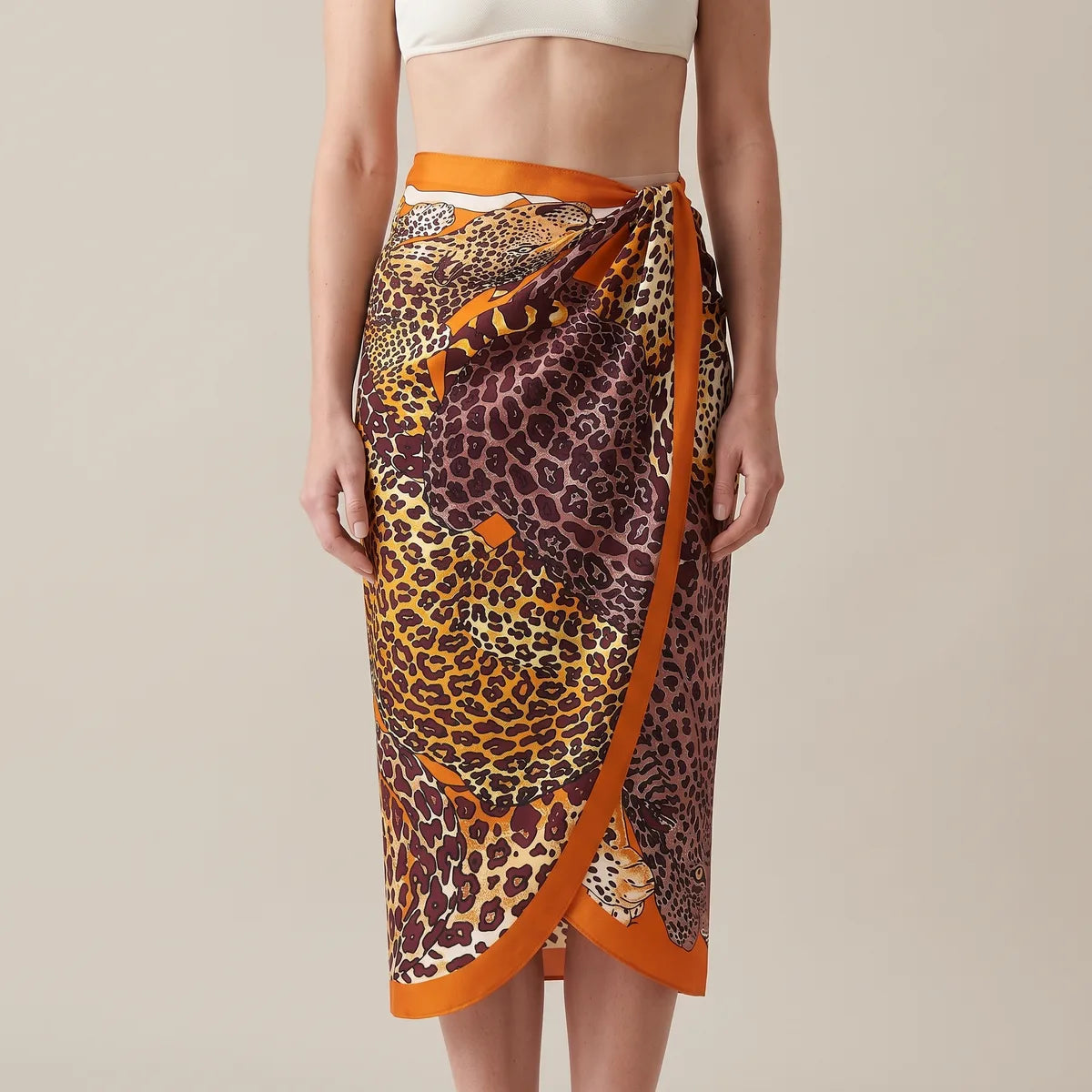 Leopard print silk shawl knotted at the hip as a sarong, the orange edge running down one side