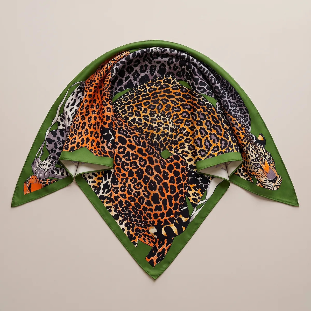 Gray and orange leopard shawl folded into a triangle with a leaf green border along both sides