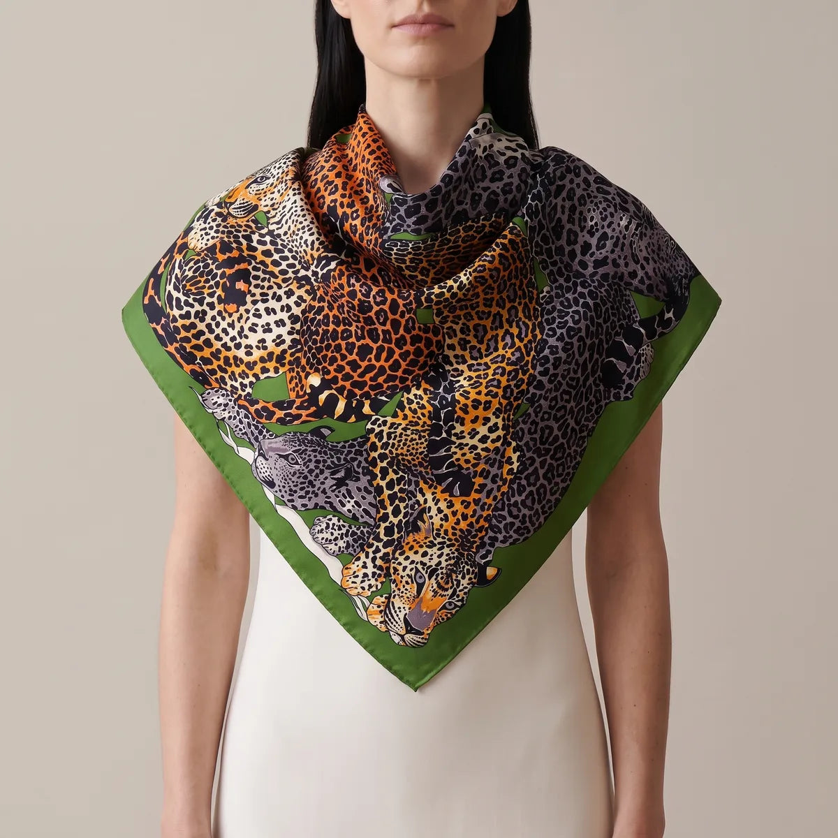 Leaf green border making a V over a cream dress, orange and gray leopards across the shoulders